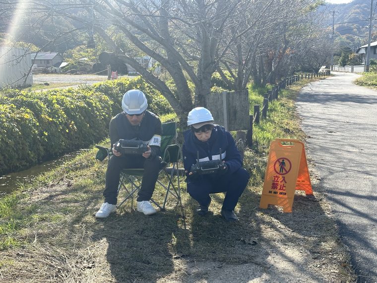 現場で機体を操作する2名の作業員