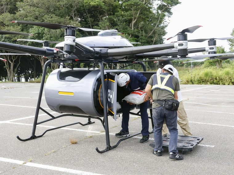 大型の物流ドローンを前に準備を進めるスタッフ